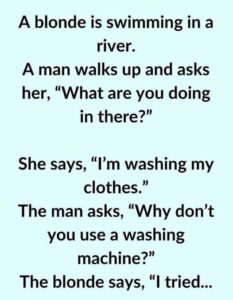 A blonde is swimming in a river.